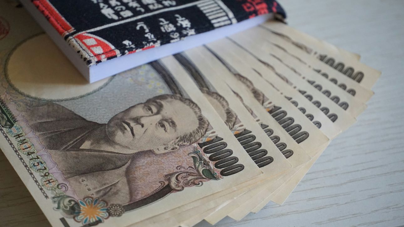 Fächerförmig ausgebreitete japanische 10.000-Yen-Banknoten auf einem Tisch.